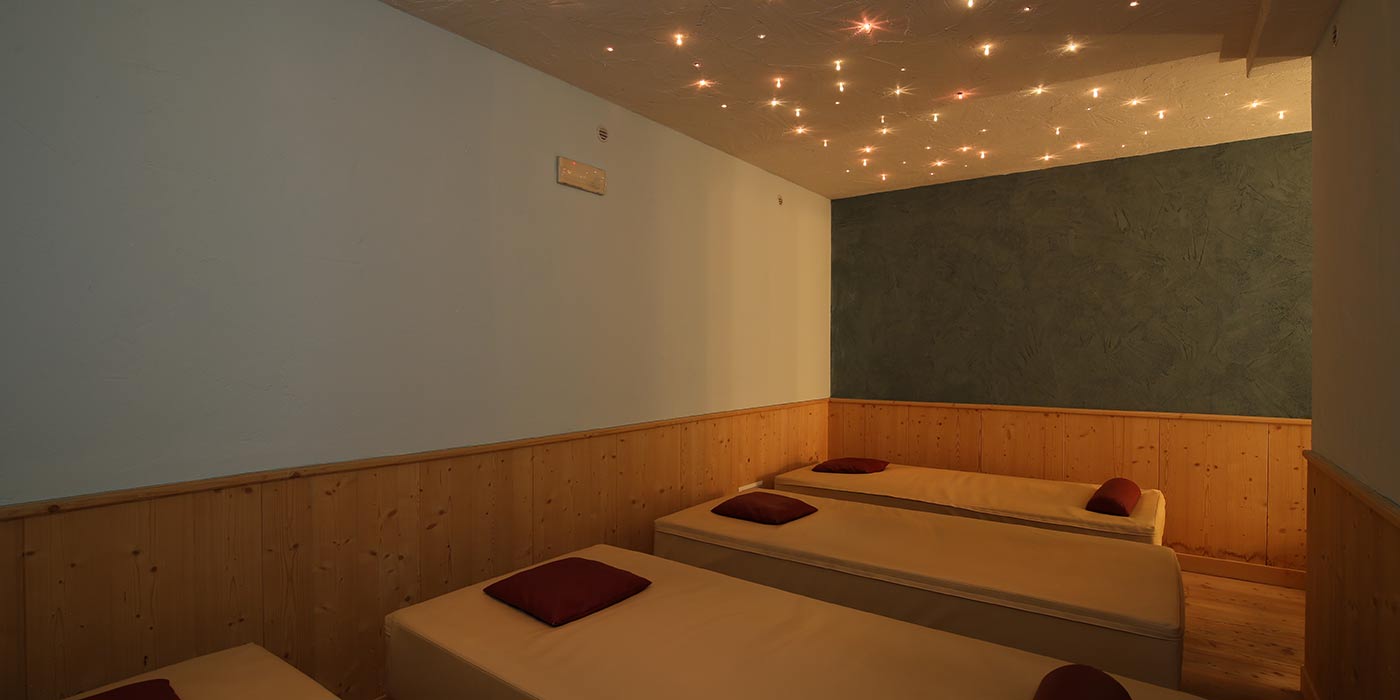 Hotel Mesdì's relax area with white sunbeds and colored lights on the ceiling