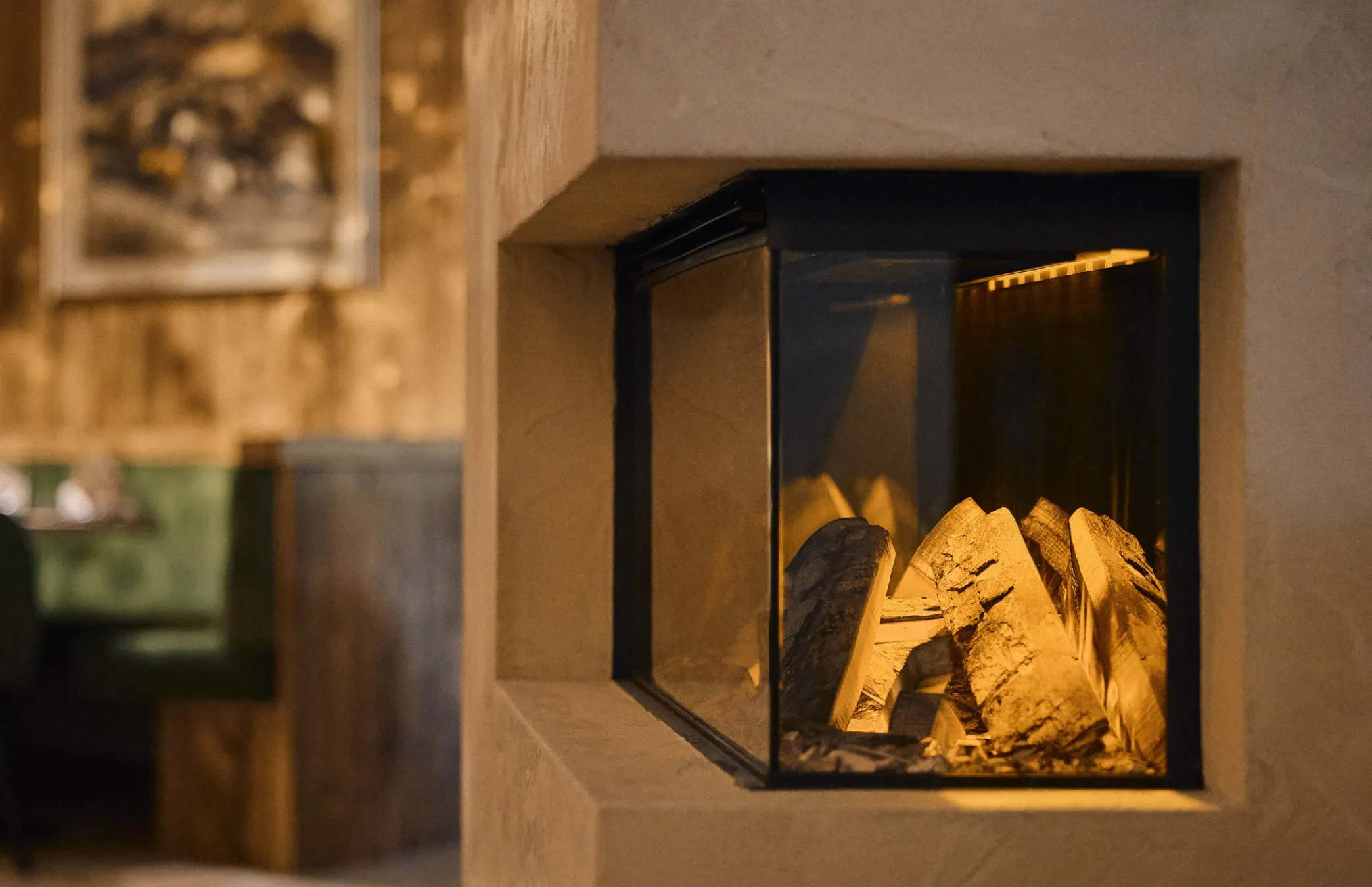 Accogliente angolo caminetto nell’area lounge dell’Hotel Mesdí ad Arabba, un’atmosfera perfetta per rilassarsi dopo una giornata nelle Dolomiti.
