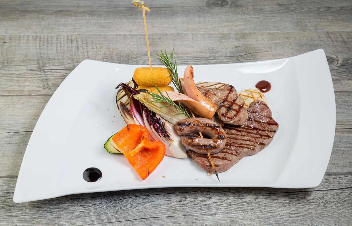 Fleischteller mit Kroketten und Gemüse