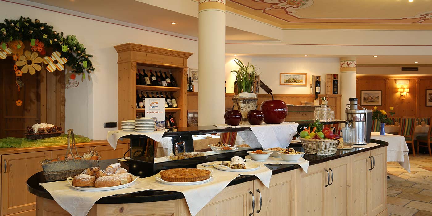 Buffet di colazione all'Hotel Mesdì con torte e altri dolci sul bancone della sala da pranzo